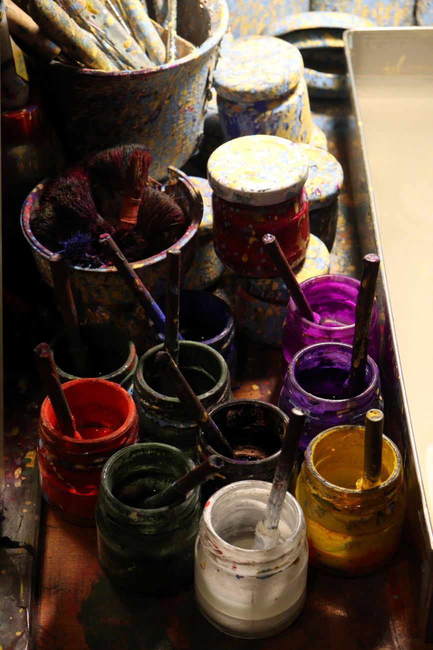 vibrant paint jars and brushes in studio